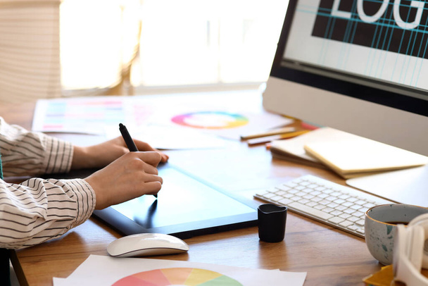 Diseñadora gráfica femenina trabajando con tablet en mesa en oficina, primer plano - Foto, imagen