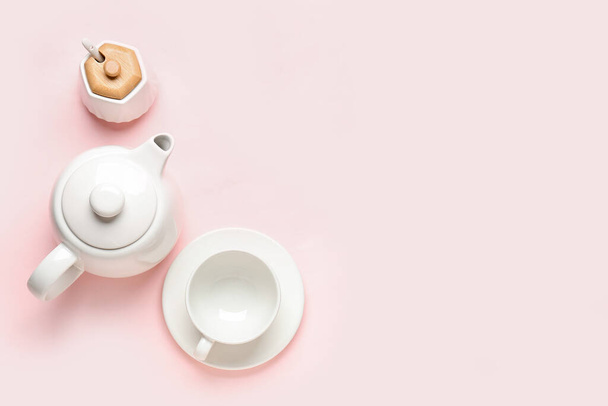 Tetera, taza y azucarero sobre fondo rosa - Foto, imagen