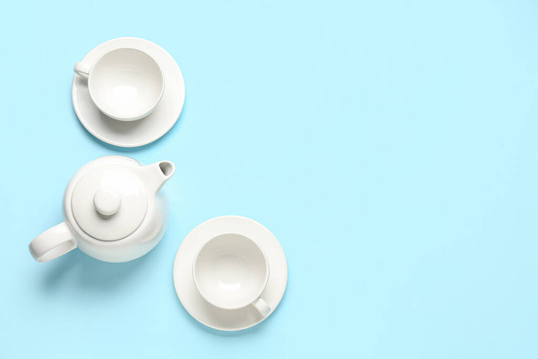 Чайник и чашки на синем фоне - Фото, изображение