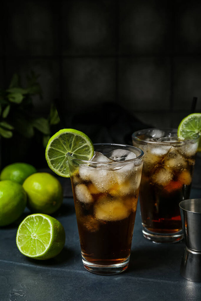 Glazen koude Cuba Libre cocktail op donkere achtergrond - Foto, afbeelding