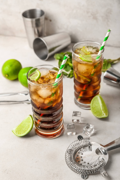 Glasses of cold Cuba Libre cocktail on light background - Фото, зображення