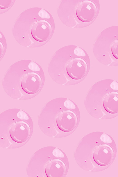 okrągłe krople przezroczystego serum żelowego na różowym tle. żel z bąbelkami. Krople wody - Zdjęcie, obraz