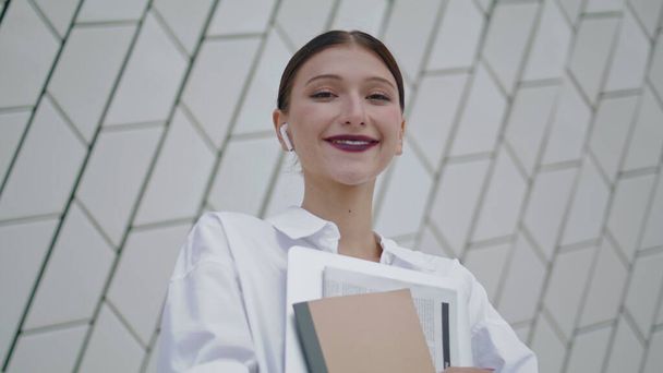 Portrait of happy professional manager posing in front modern building wall. Confident beautiful woman holding work documents. Attractive office worker with folder smiling looking at camera close up. - Photo, Image