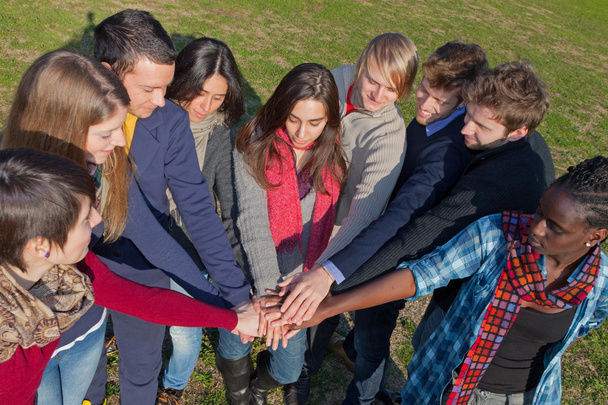 Estudiantes universitarios felices con manos en la pila
 - Foto, imagen