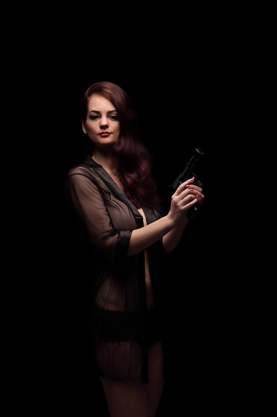 Danger woman with gun. Dark colors. - Фото, изображение