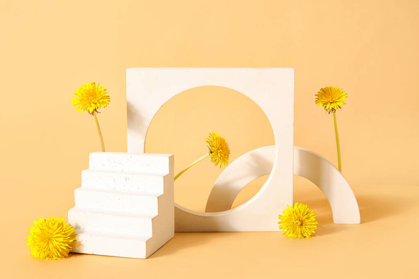 Pódiums decorativos con flores de diente de león sobre fondo beige - Foto, Imagen