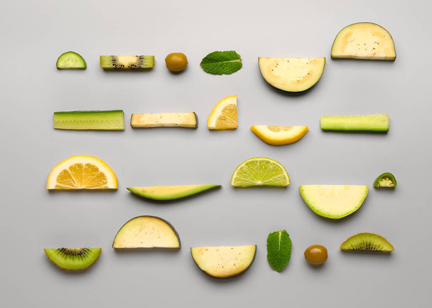 Composition with green fresh fruits and vegetables on grey background - Photo, Image