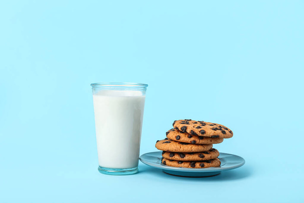 Glass of milk and cookies on light blue background - Фото, зображення