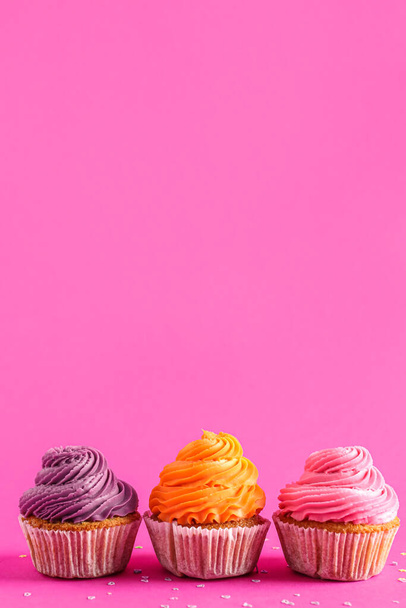 Cupcakes coloridos saborosos no fundo rosa - Foto, Imagem