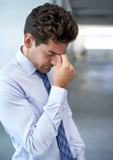 Burnout imminent. A young businessman looking stressed-out at the office - Foto, imagen