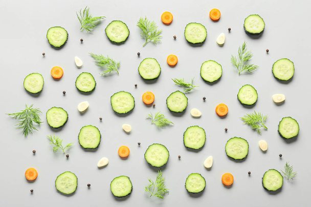 Slices of cucumber with dill and carrot on grey background - Foto, Imagen