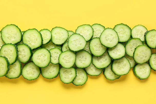 Snijwonden van komkommer op gele achtergrond - Foto, afbeelding