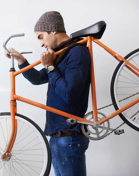 A trabajar con su bicicleta de confianza. un joven de moda llevando su bicicleta dentro - Foto, Imagen