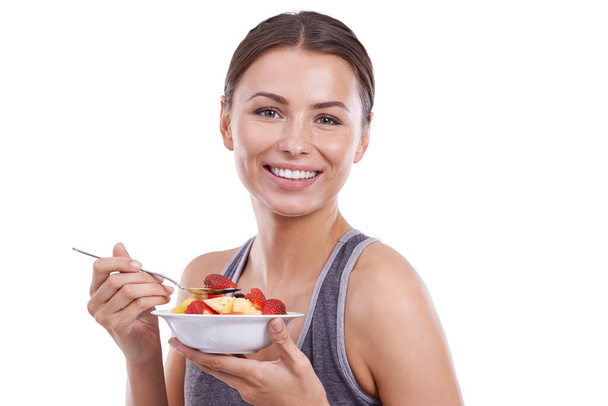 Getting some energy for her workout later. Portrait of an attractive young woman eating a bowl of fruit salad - Φωτογραφία, εικόνα