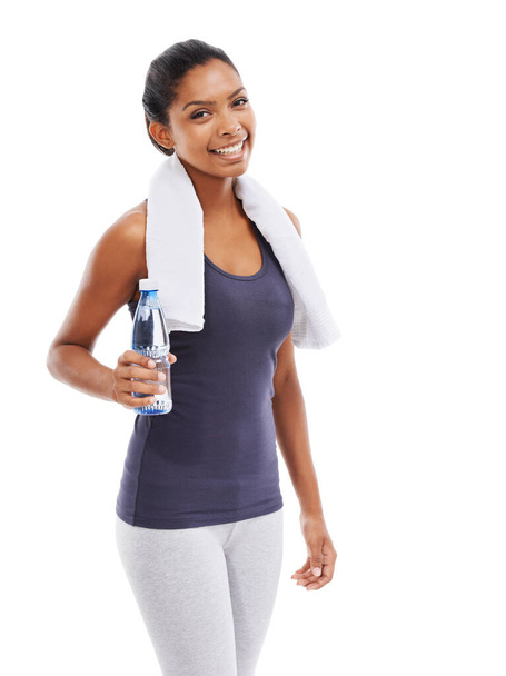 Пополнение жидкости - Упражнение. Молодая женщина держит бутылку воды после напряженной тренировки - Фото, изображение