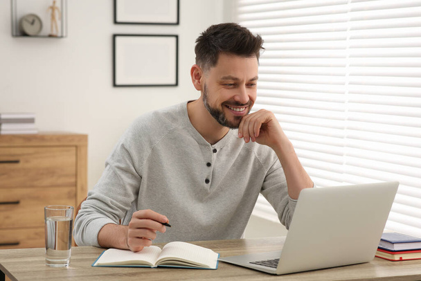Man studying on laptop at home. Online translation course - Fotó, kép