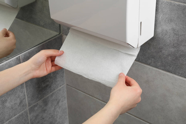 Woman taking new fresh paper towel from dispenser in bathroom, closeup - Valokuva, kuva