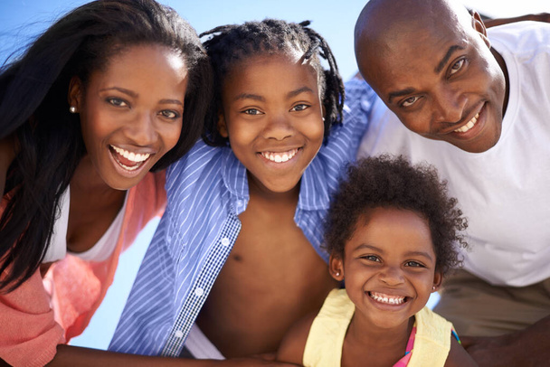 群れのために行く。幸せなアフリカ系アメリカ人の家族が一緒にビーチで一日を過ごしている様子の低ビューの肖像画 - 写真・画像