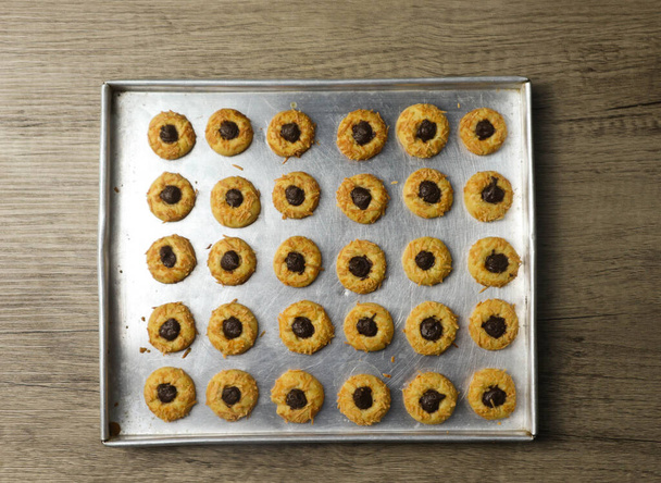Μπισκότα με επικάλυψη τυριού με γέμιση σοκολάτας, μπισκότα αντίχειρα φρέσκα από το φούρνο στο αλουμινένιο τηγάνι - Φωτογραφία, εικόνα