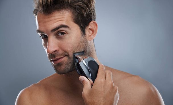 Как можно ближе к бритью. Молодой человек бреется электрической бритвой - Фото, изображение