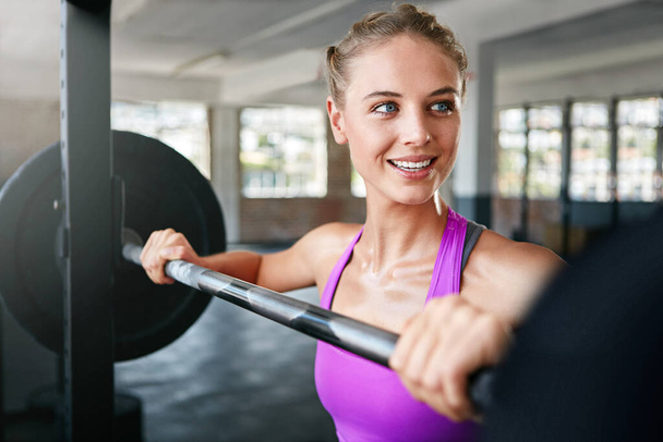Ich selbst und Eisen. Eine junge Frau trainiert im Fitnessstudio mit Gewichten - Foto, Bild