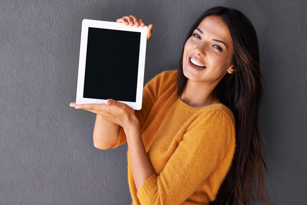 Mi salvavidas. Retrato de una joven atractiva sosteniendo una tableta digital con una pantalla en blanco - Foto, imagen