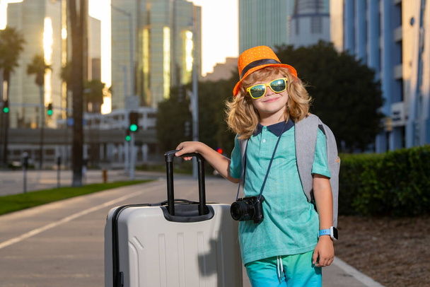 Child boy and travel Suitcase. Kid and Luggage Packed for vacation, child trip. Little tourist with travel bag. Child traveler and baggage. Kid with luggage bags going on holiday trip - Fotó, kép