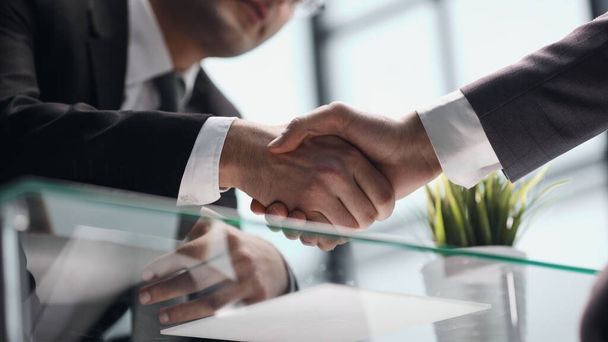 Close up businessman shaking hands with caucasian client. - Фото, изображение
