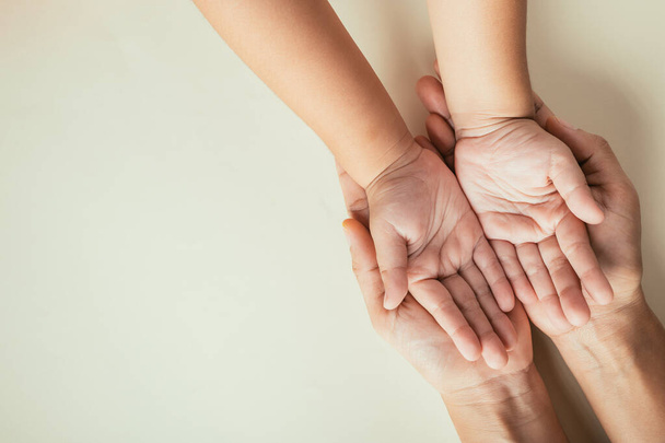 Close up hands children on adult mother hand, Top view person kid stack mom palms, Parents and little kid holding empty hands together isolated on pastel background, Family day care concept - Foto, imagen