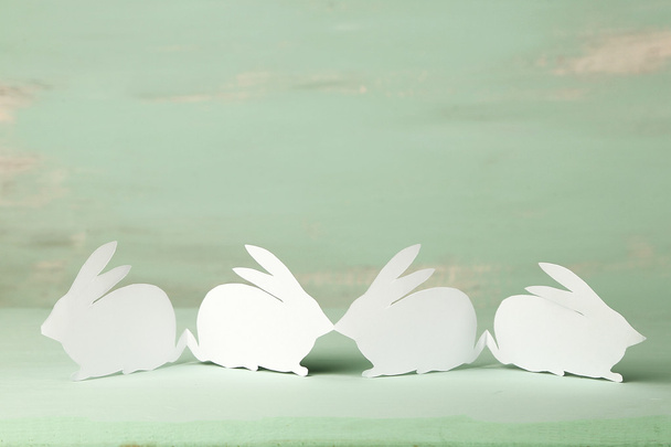 Paper Easter rabbits on color wooden background - Φωτογραφία, εικόνα