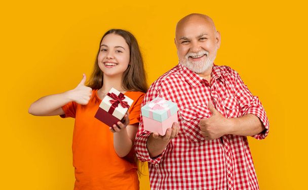 cheerful kid and grandfather with present box for anniversary. - Fotó, kép