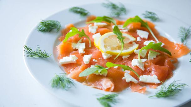 Salmon carpaccio with cheese, lemon and salad. - Foto, imagen
