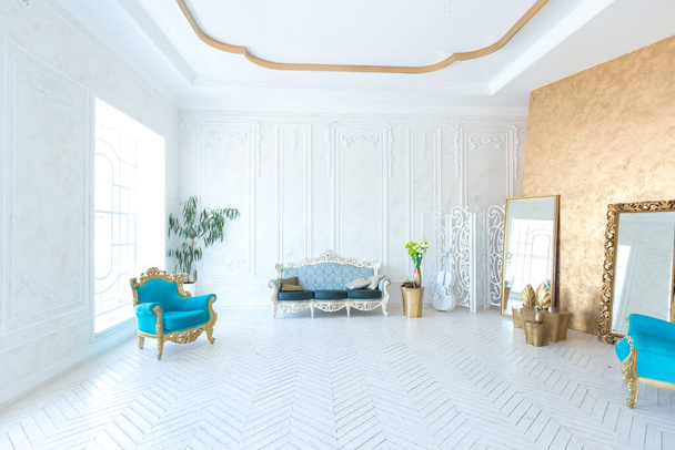 Luxury light interior of living room with gold wall and chic expensive furniture in white and gold colors - Foto, imagen