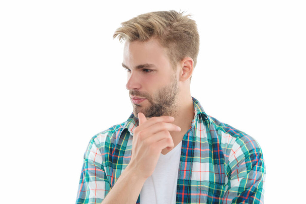 pondering millennial guy on background. millennial guy in studio. photo of millennial guy wearing checkered shirt. millennial guy isolated on white. - Valokuva, kuva