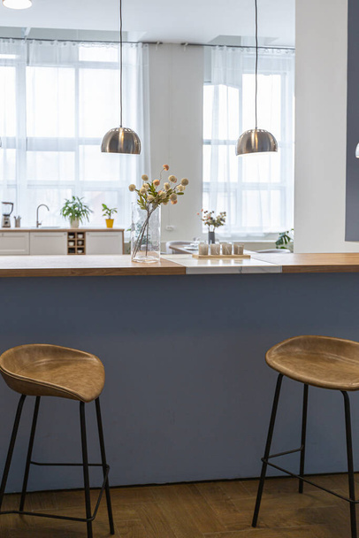 minimalistický moderní design interiéru obrovský světlý byt s otevřeným plánem ve skandinávském stylu v bílé, modré a tmavě modré barvy se sloupy v centru. zahrnuje kuchyňský kout, kancelář a salonek - Fotografie, Obrázek