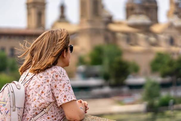 Kobieta-turystka podziwiająca wysokie wieże bazyliki katedralnej El Pilar w zabytkowym mieście Saragossa, Hiszpania - Zdjęcie, obraz