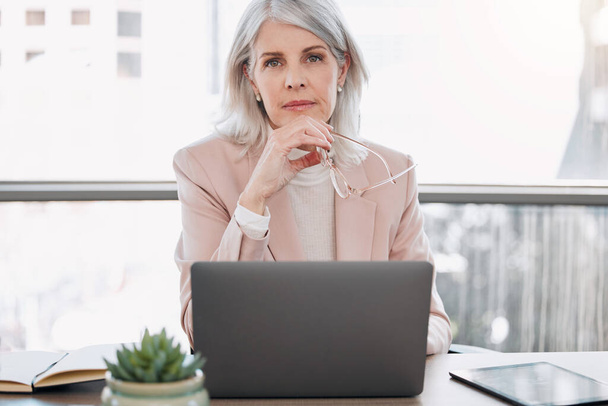 Es gibt immer Möglichkeiten, sich zu verbessern. eine reife Geschäftsfrau, die allein im Büro sitzt und nachdenklich schaut, während sie ihren Laptop benutzt - Foto, Bild