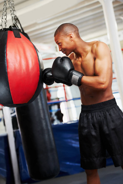 Dávám do toho těžké hodiny. Africký americký boxer cvičí s děrovacím míčkem - Fotografie, Obrázek