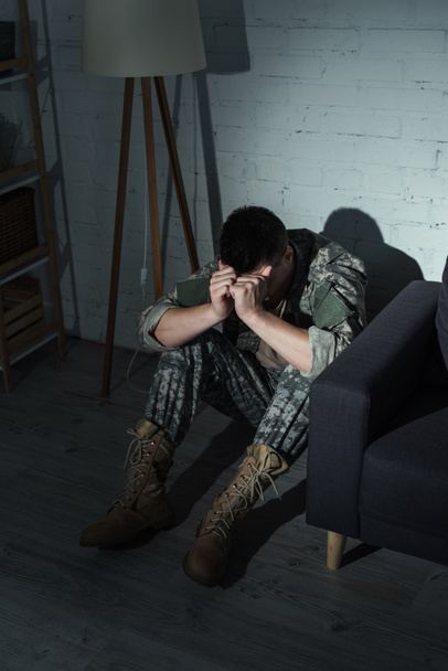 Στρατιώτης με στολή που υποφέρει από διαταραχή διαχωρισμού στο σπίτι τη νύχτα  - Φωτογραφία, εικόνα