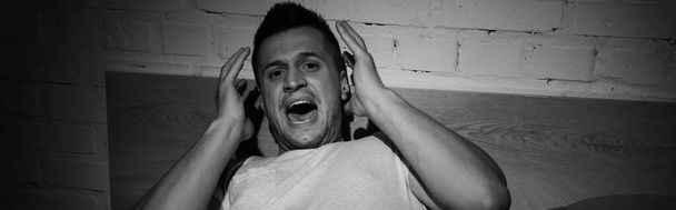 монохромное фото стрессового человека с паническими атаками, кричащего ночью, баннер  - Фото, изображение