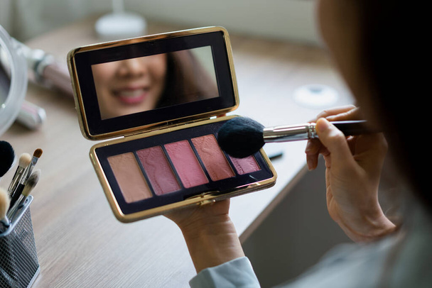 Beauty blogger use brush with blush on to applying product for reviewing cosmetic in makeup vlogger. - 写真・画像