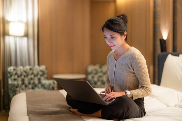 Nő dolgozik laptop számítógép az ágyban este - Fotó, kép