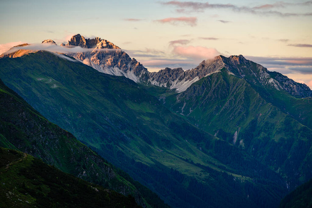 Cordillera Kalkkogel con su pico más alto Schlicker Seespitze y Hoher Burgstall en Stubai Alpes con luz naranja al atardecer.  - Foto, Imagen