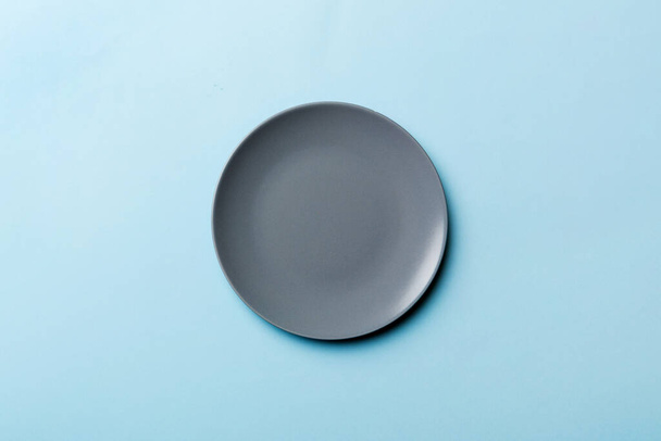 Top view of isolated of colored background empty round gray plate for food. Empty dish with space for your design. - Photo, image