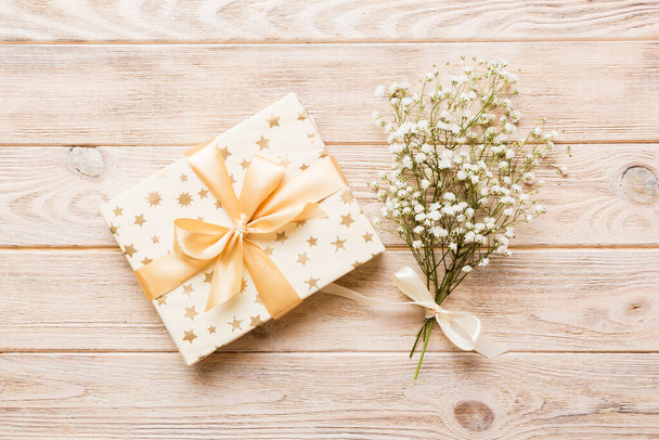 Gift or present box and flower gypsophila on light table top view. Greeting card. Flat lay style with copy space. - Foto, afbeelding