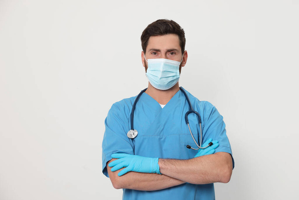 Krankenschwester mit medizinischer Maske und Stethoskop auf weißem Hintergrund - Foto, Bild