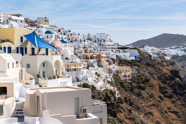 The village of Oia with typical white cave houses on a sunny day - Foto, imagen