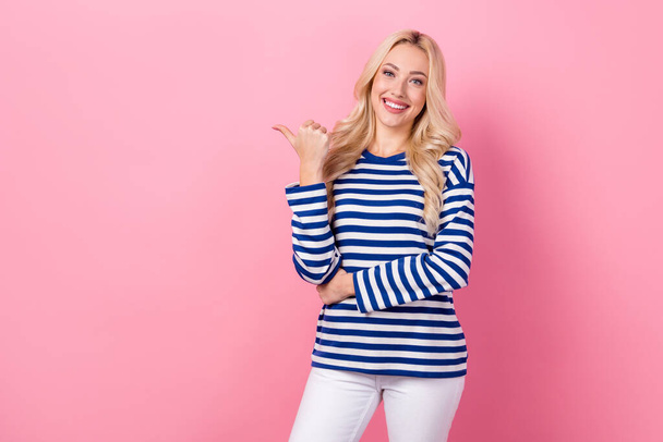 Photo of young promoter girl wear striped pullover point finger empty space ad price list beauty salon isolated on pink color background. - Fotoğraf, Görsel