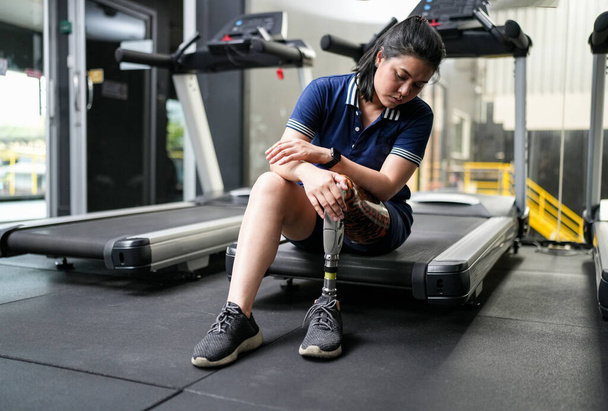 Portrait of disabled athlete woman with prosthetic leg in fitness gym - Фото, изображение