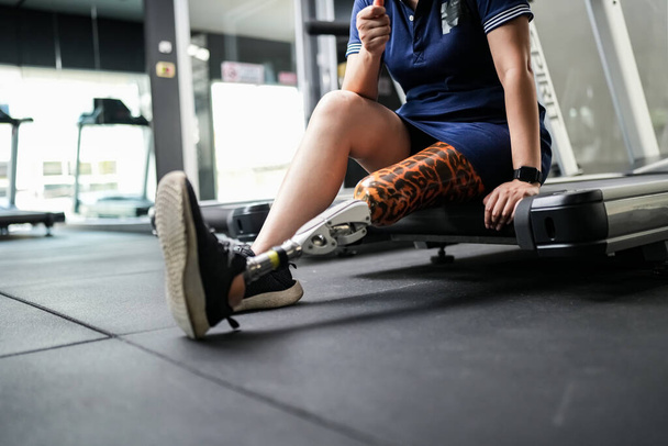 Retrato de mujer atleta discapacitada con pierna protésica en gimnasio - Foto, Imagen